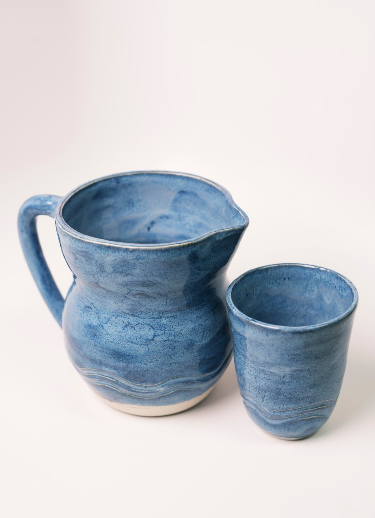 Blue pitcher with a matching cup, carved wavy lines near the base